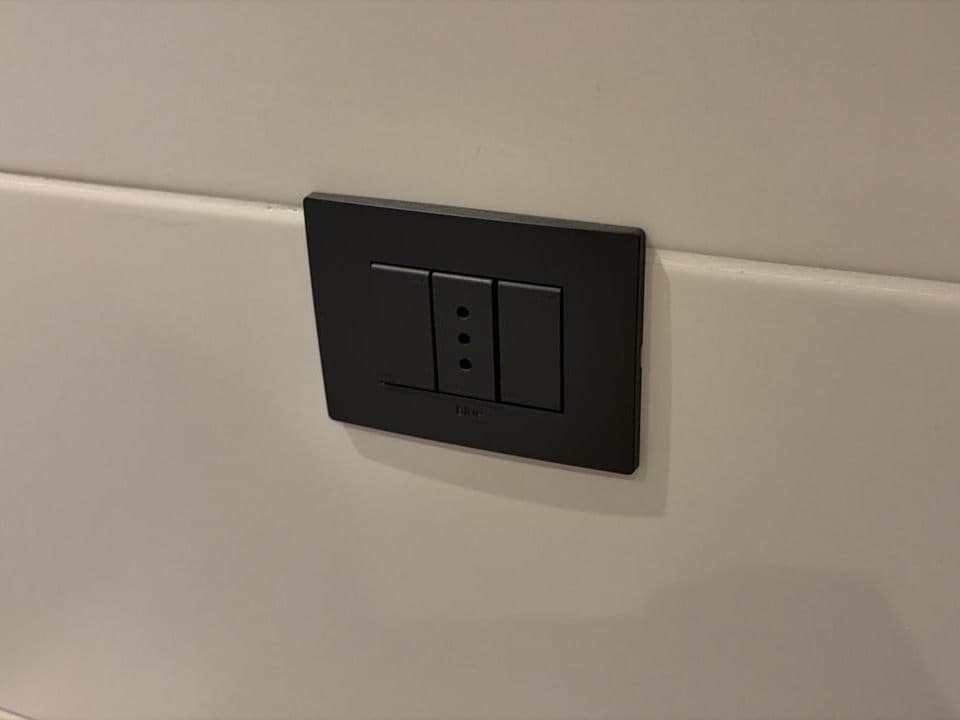 Placa con enchufe e interruptores recién instalada en un muro