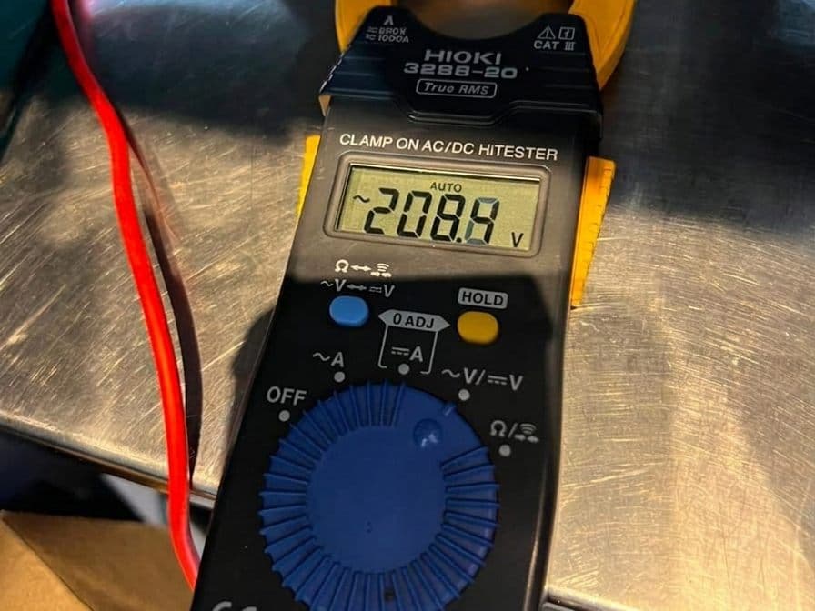 Pinza amperimétrica midiendo la tensión de una instalación durante un diagnóstico