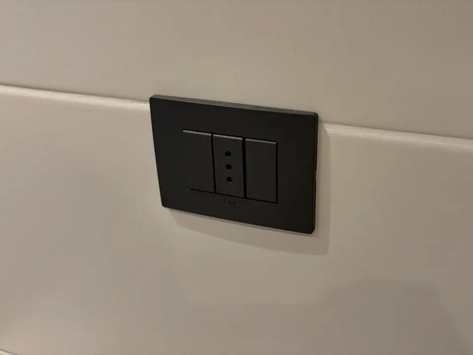 Placa con enchufe e interruptores recién instalada en un muro